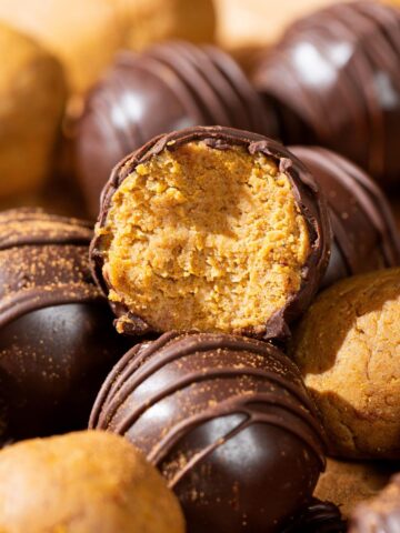 Pumpkin cake pops on top of each other.
