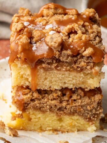 Caramel coffee cake on a white plate with crumbs around it.