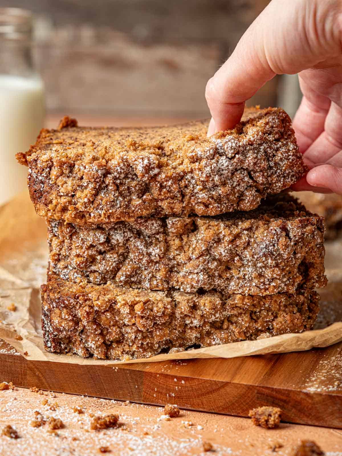 Slices of banana bread with streusel topping on a cutting board.