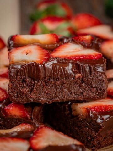 Strawberry chocolate brownies stacked showing the textures of the brownies.