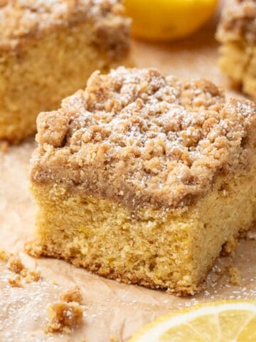 Cardamom coffee cake on parchment paper with crumbs around.